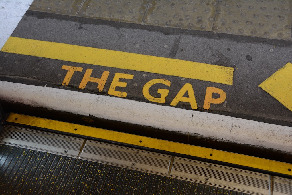 station platform pavement with the phrase the gap printed in yellow on the floor